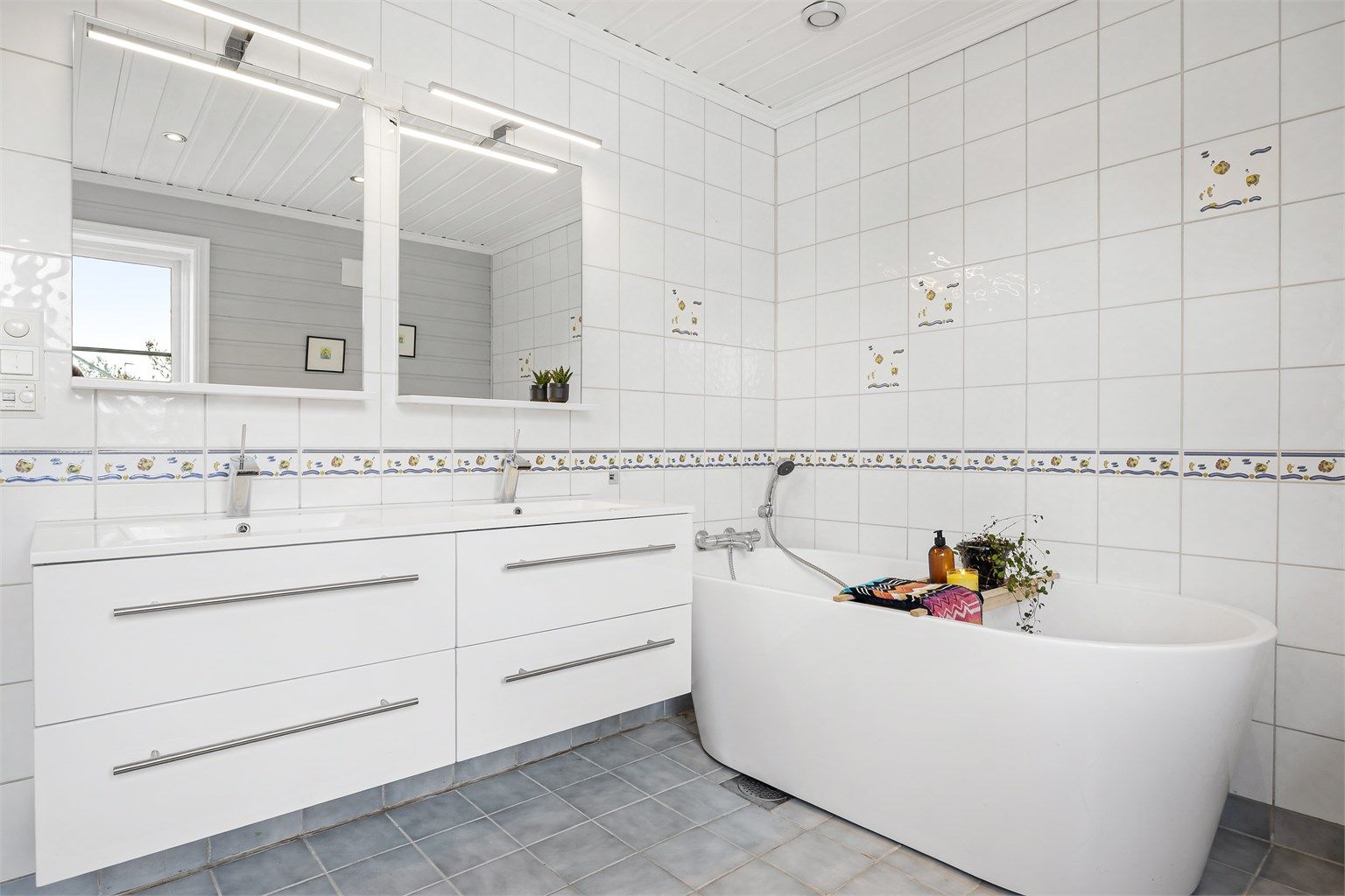 Badet i første etasje har badekar, gulvvarme og innredning med to servanter.