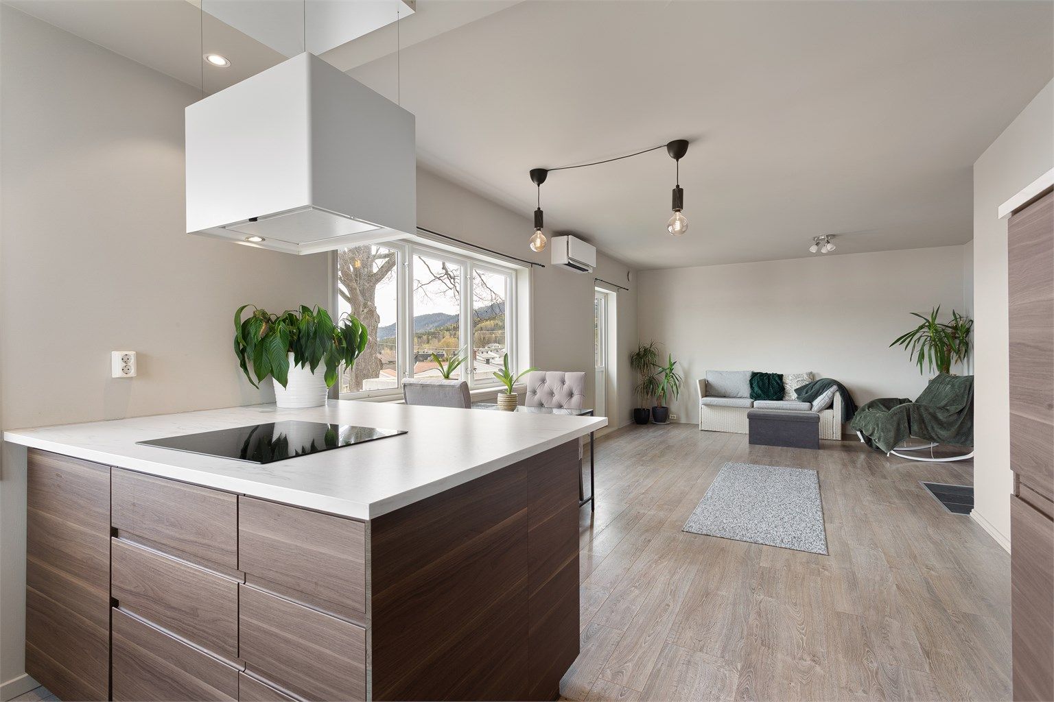 Den åpne planløsningen skaper en sosial og luftig atmosfære mellom kjøkken og stue.