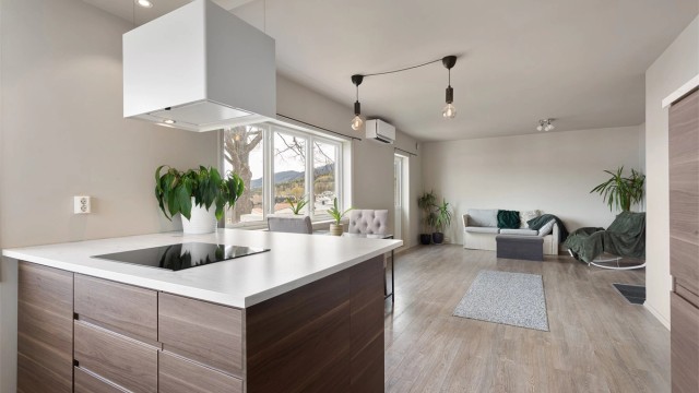 Den åpne planløsningen skaper en sosial og luftig atmosfære mellom kjøkken og stue.