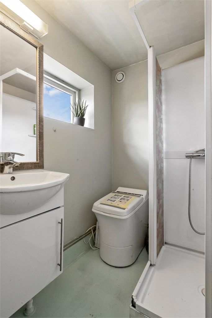 Rom benyttet som bad i kjelleren har dusjkabinett, servantskap og Cinderella forbrenningstoalett.