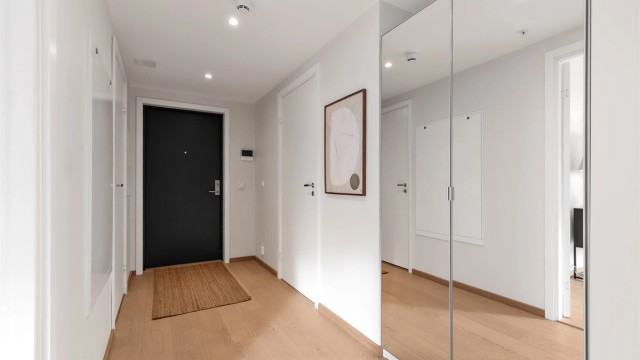 Romslig entré med plass til garderobeskap for oppbevaring av ytterklær og sko. Fra entreen kommer man videre til badet, begge soverommene, toalettrommet og stuen/kjøkkenet.