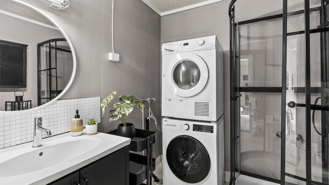 Badet er innredet med gulvstående servantinnredning, speil med overlys, dusjkabinett med dusjarmatur og gulvstående toalett. Det er opplegg for vaskemaskin.