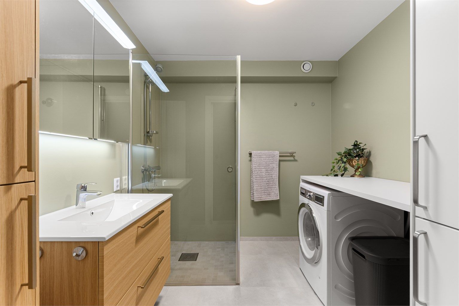 Badet er holdt i
 moderne og tidløse fargetoner, som står svært godt til baderomsmøblene i eikeutførelse