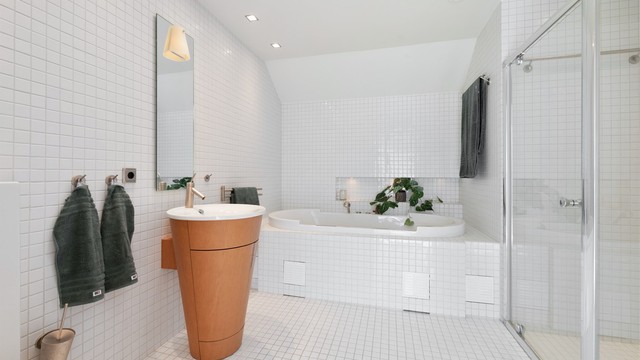 Flislagt bad mot nord med Duravit servant, dusjhjørne, gulvvarme og innfliset boblebadekar fra Philippe Starck.