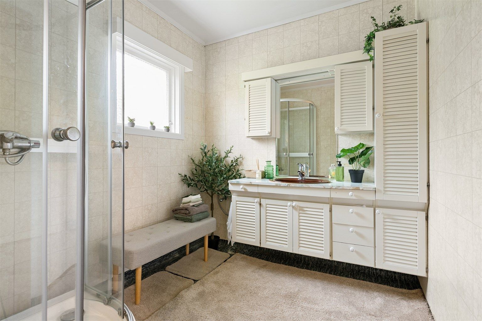 Badet i hovedetasjen er fra byggeåret og har dusjkabinett og en romslig innredning med servant.