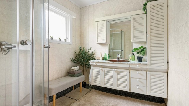 Badet i hovedetasjen er fra byggeåret og har dusjkabinett og en romslig innredning med servant.