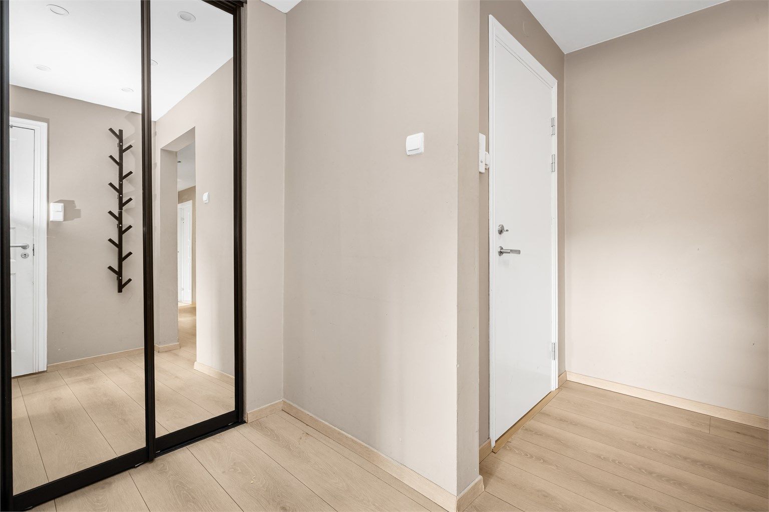 Romslig entré med skyvedørsgarderobe.