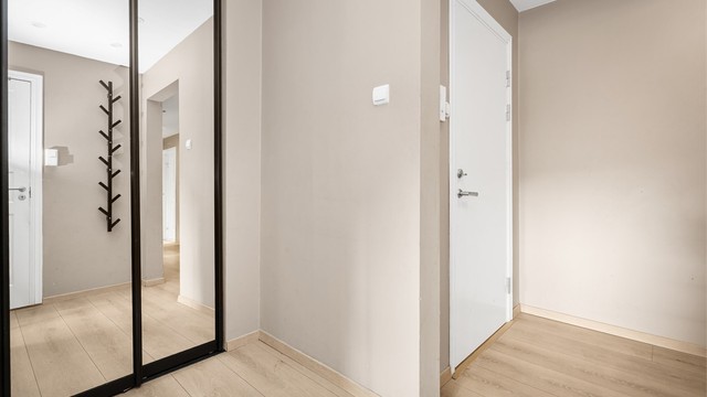 Romslig entré med skyvedørsgarderobe.