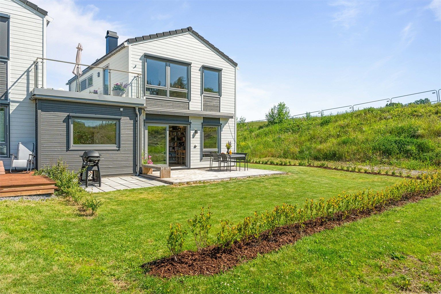 Fra stuen i første etasje kommer du ut til en terrasse og privat hage.