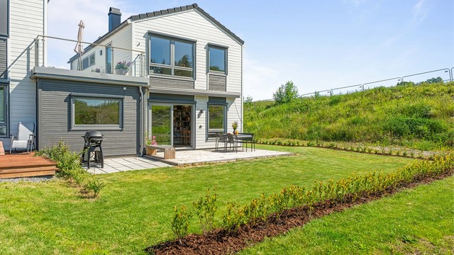 Fra stuen i første etasje kommer du ut til en terrasse og privat hage.