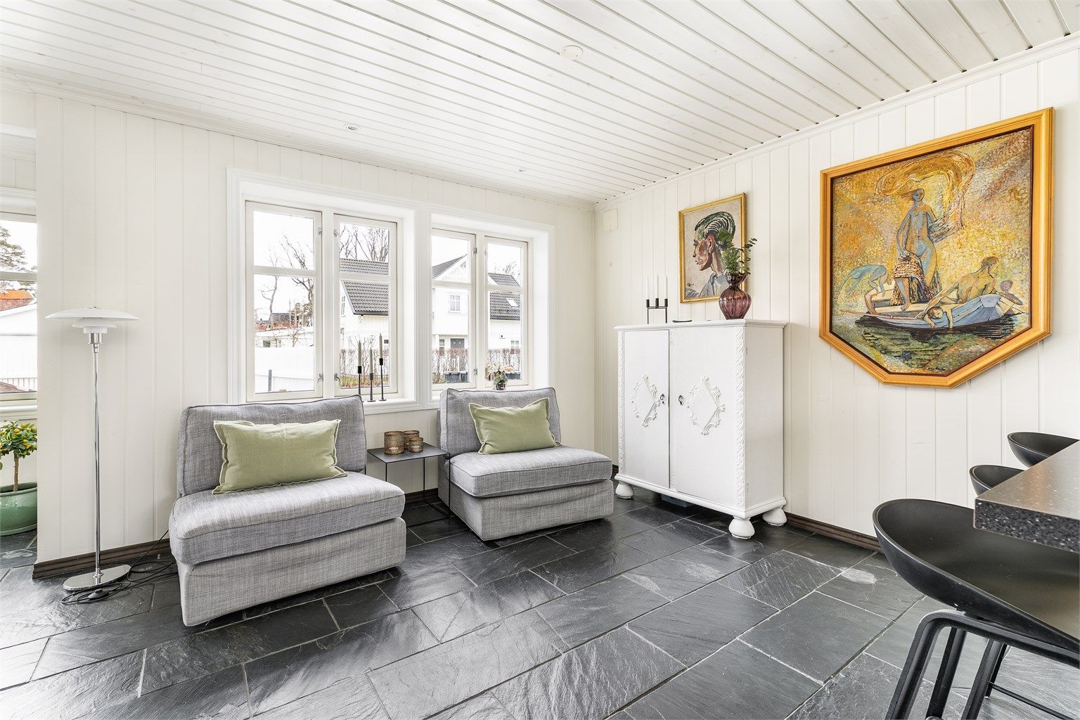 I den langstrakte stuen er det rom for flere soner og sittegrupper. Et større antall vinduer i vestveggen besørger meget gode lysforhold.