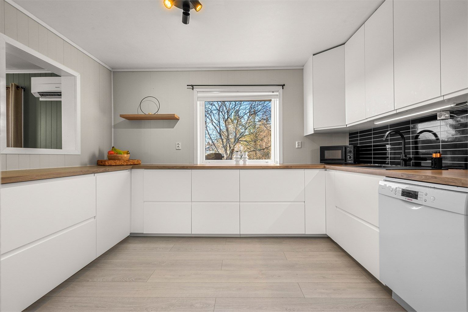 Moderne IKEA-kjøkken fra 2025 med lyse, glatte fronter og benkeplate i tre.
