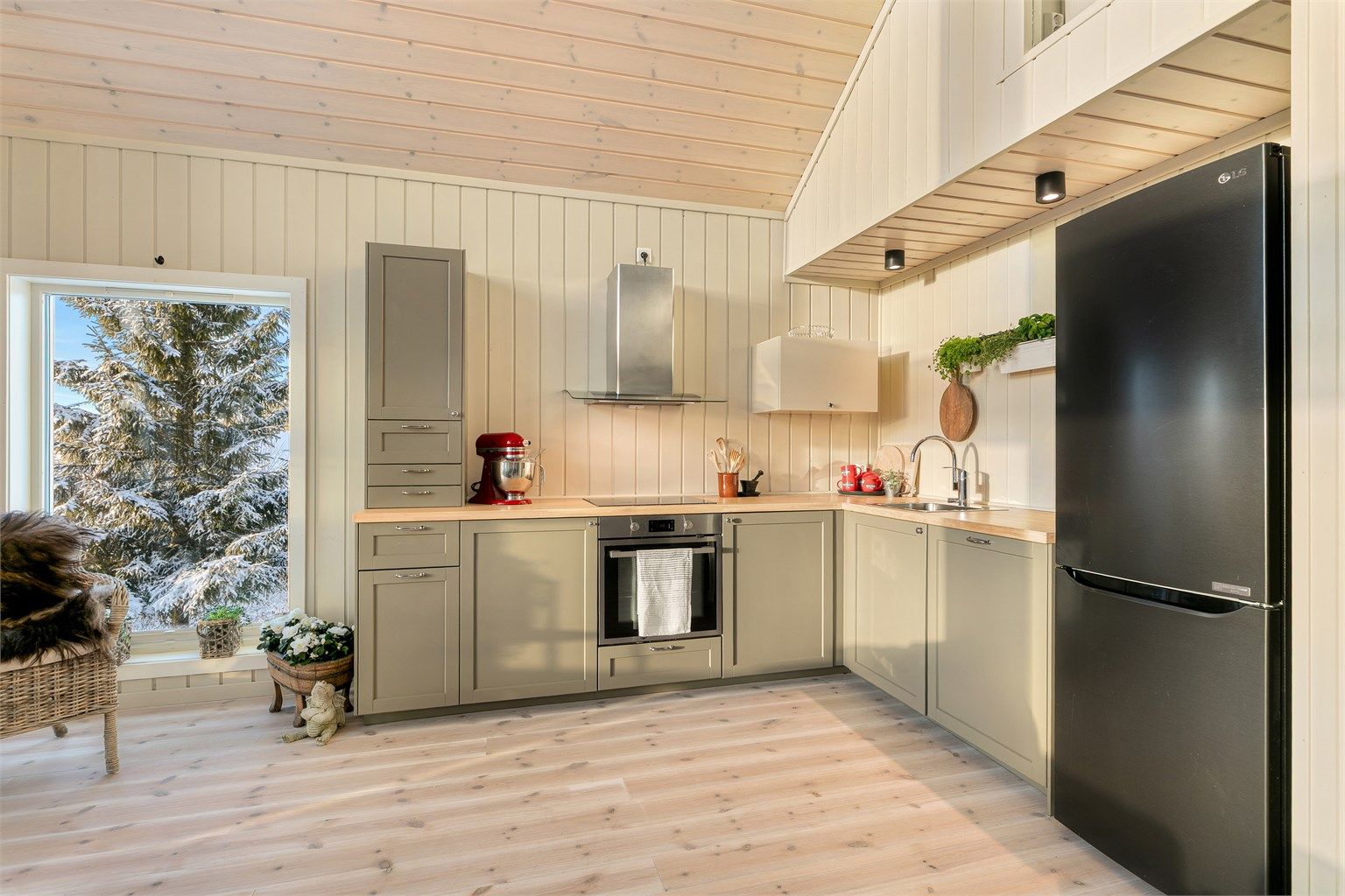 Kjøkkenet er tidløst og praktisk, oppført i en funksjonell L-form med god arbeidsflyt og skapplass. 