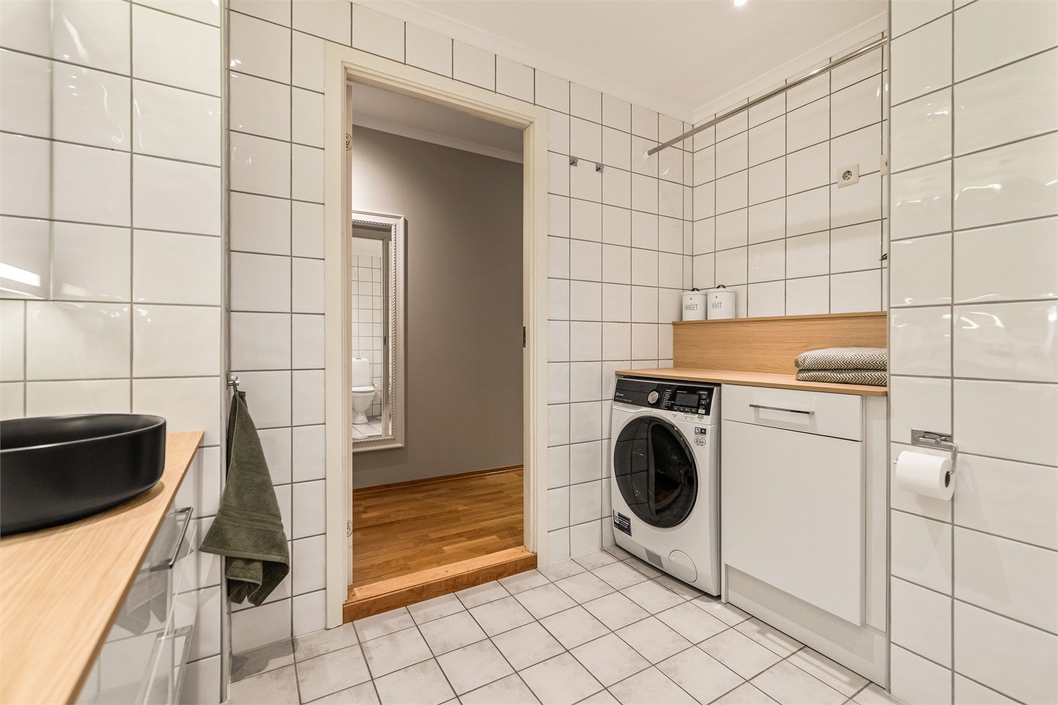 Flislagt bad med gulvvarme og praktisk nisje med opplegg for vaskemaskin.