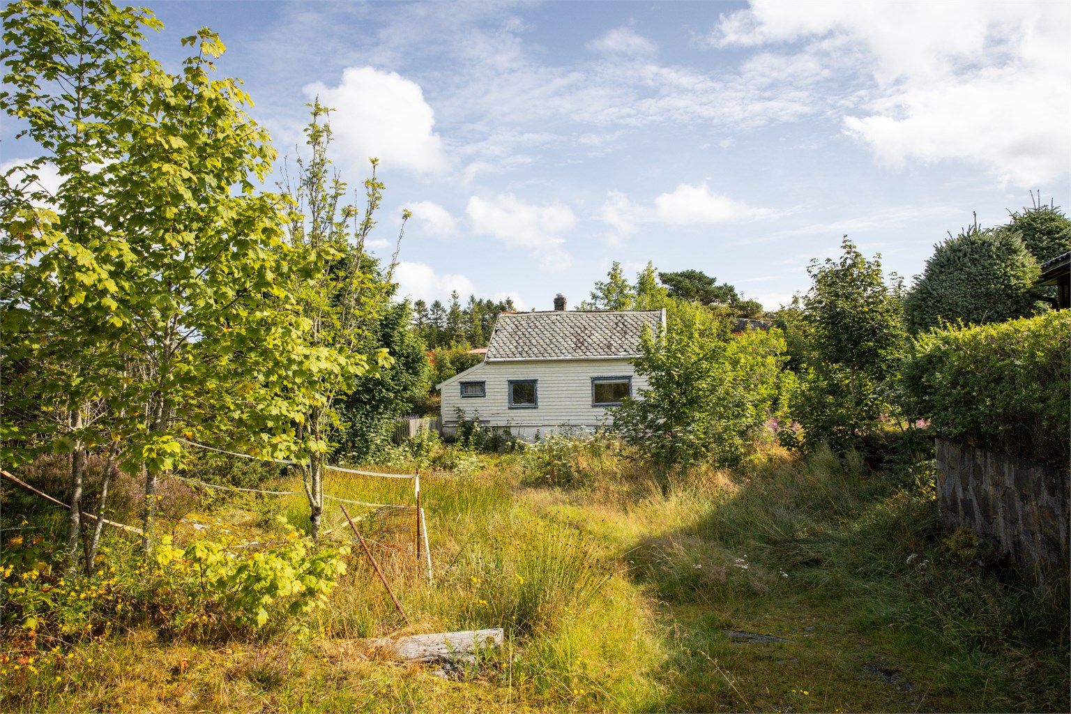 Bilde av bolighuset på eiendommen. Bolighuset er målt til 84 m² fordelt over 2 etasjer.