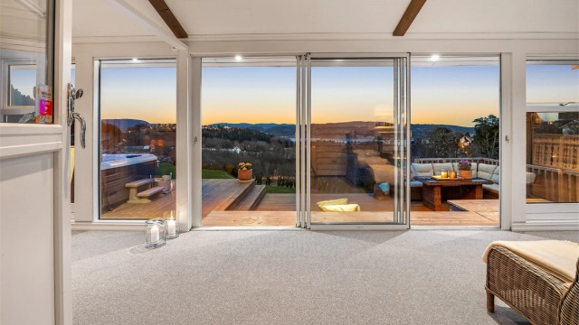 Den østvendte vinterhagen på ca. 22 m² ble bygget i 2022 og har skyvedører i glass som visker ut skillet mellom inne og ute.