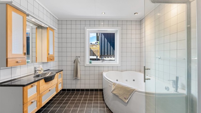 Baderom i første etasje med både dusjkabinett og frittstående boblebadekar.