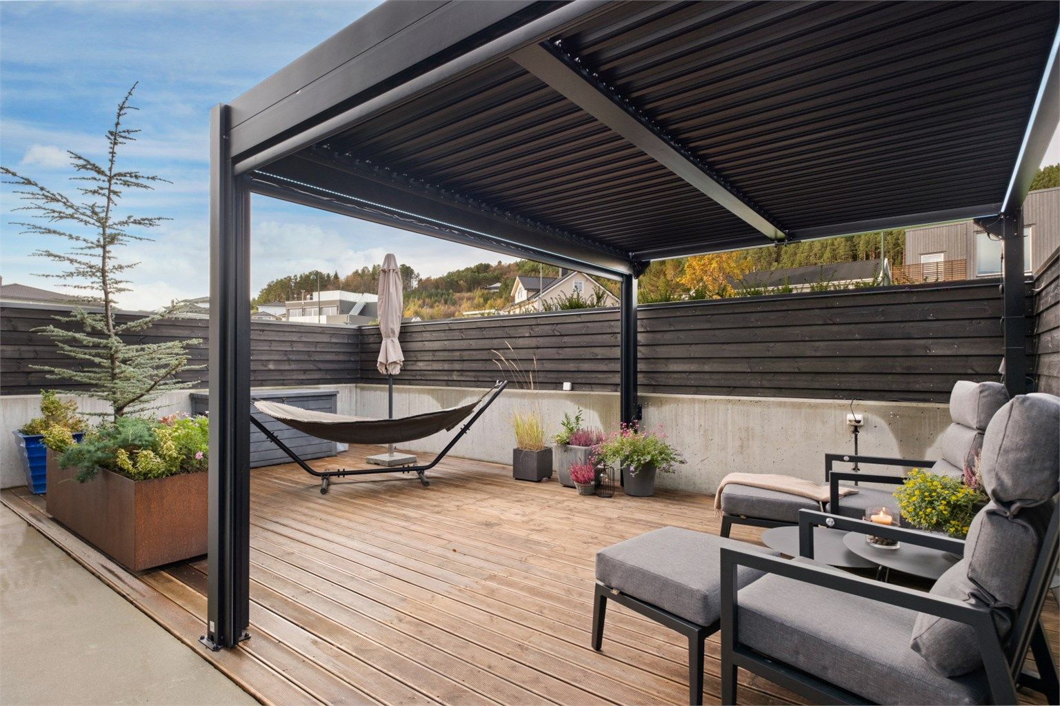 Flott skjermet uteplass mot nordvest med påstående pergola