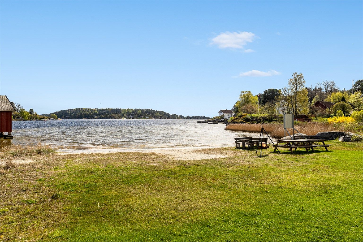Rett nedenfor huset er det en fin felles sandstrand med gresslette, sittebenker og bålplass.