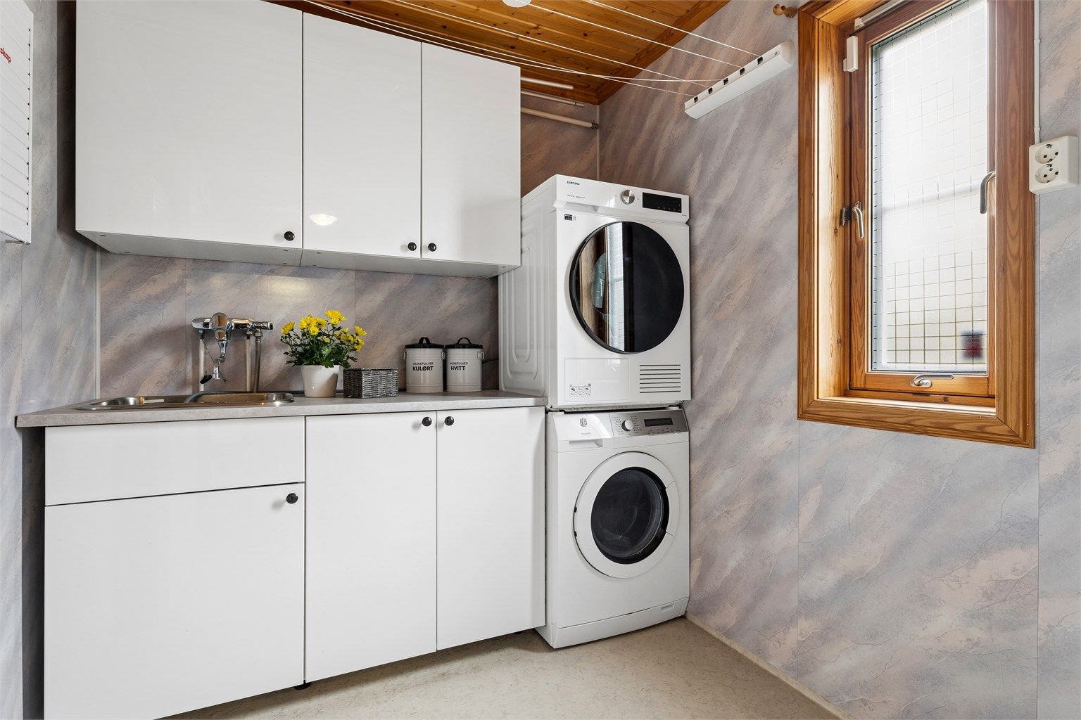 I tillegg er det et separat vaskerom med opplegg for vaskemaskin og tørketrommel, som gir en praktisk løsning i hverdagen.