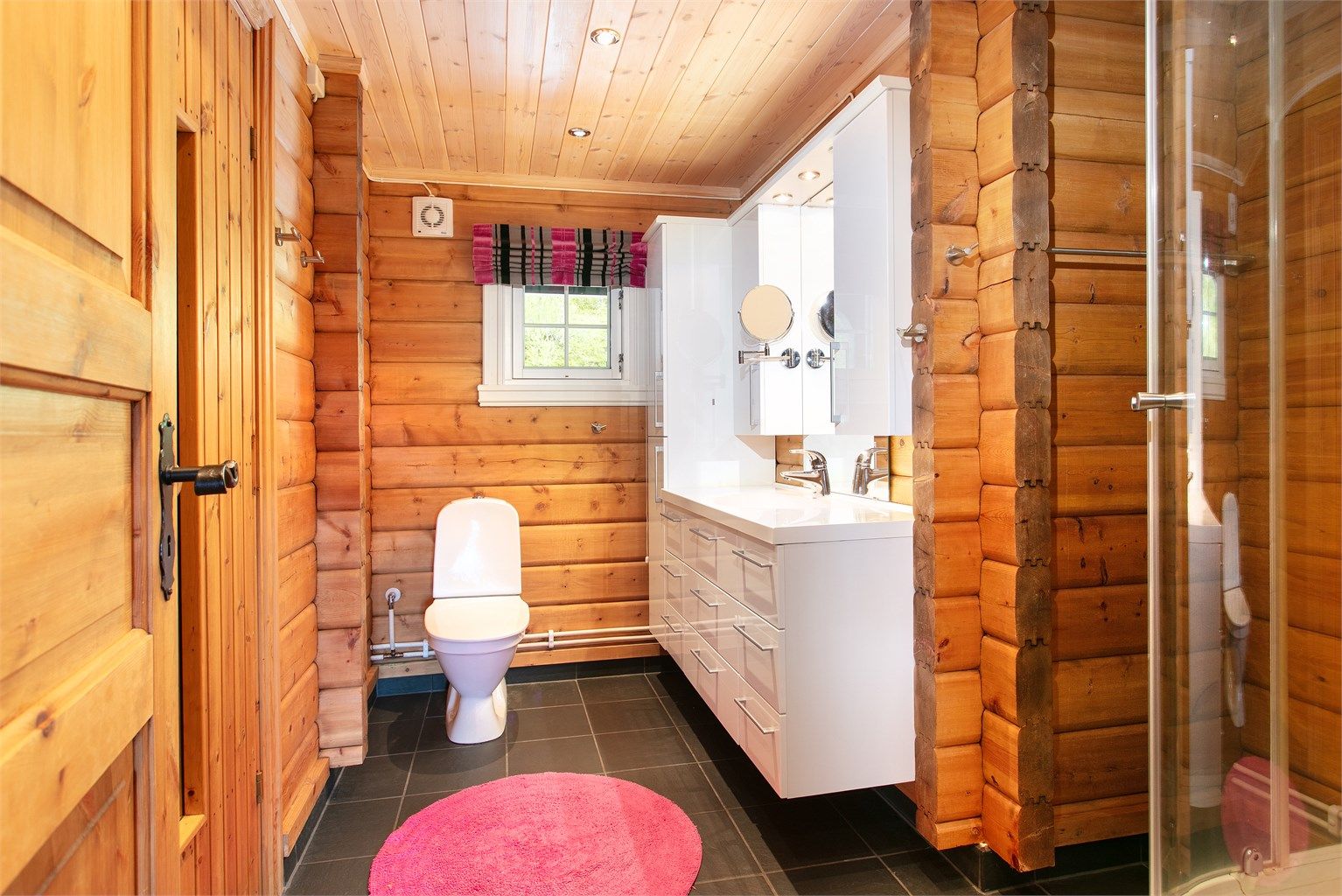Badet har flislagt gulv med elektriske varmekabler og dusjkabinett.
