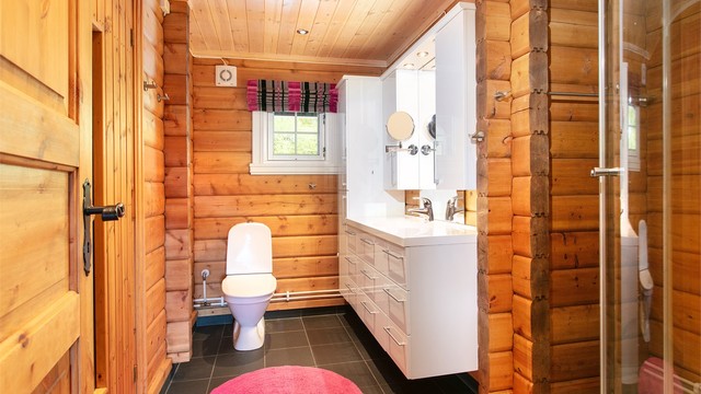 Badet har flislagt gulv med elektriske varmekabler og dusjkabinett.