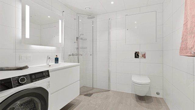 Hovedbadet er av god størrelse med opplegg for vaskemaskin. Tidløse og lekre fliser på vegg og gulv.