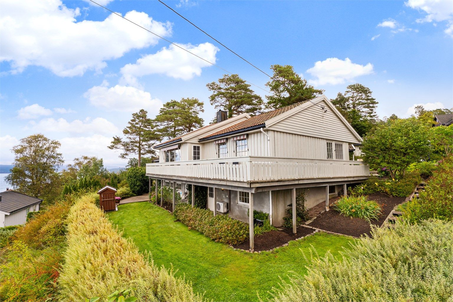 Fasade og flott opparbeidet tomt/hage.