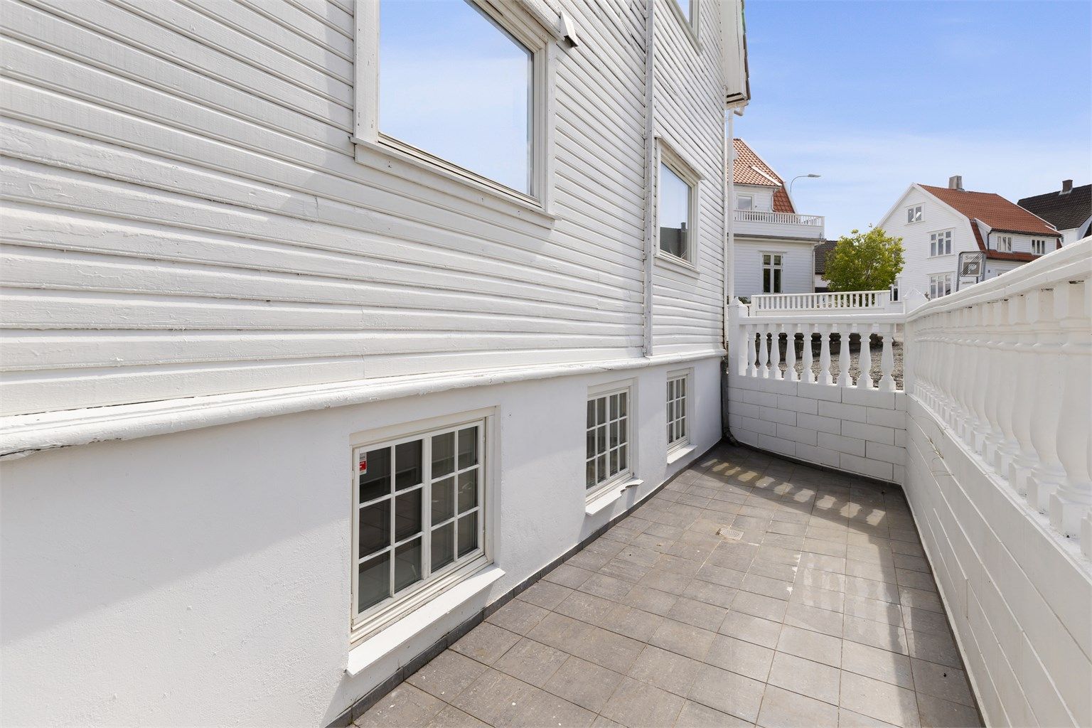 Leiligheten ligger i bygningens sokkeletasje med rom under terrengnivå.