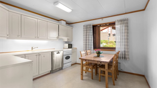 Kjøkken med innredning med profilerte fronter og benkeplater med laminert overflate. Plass til kjøkkebord.