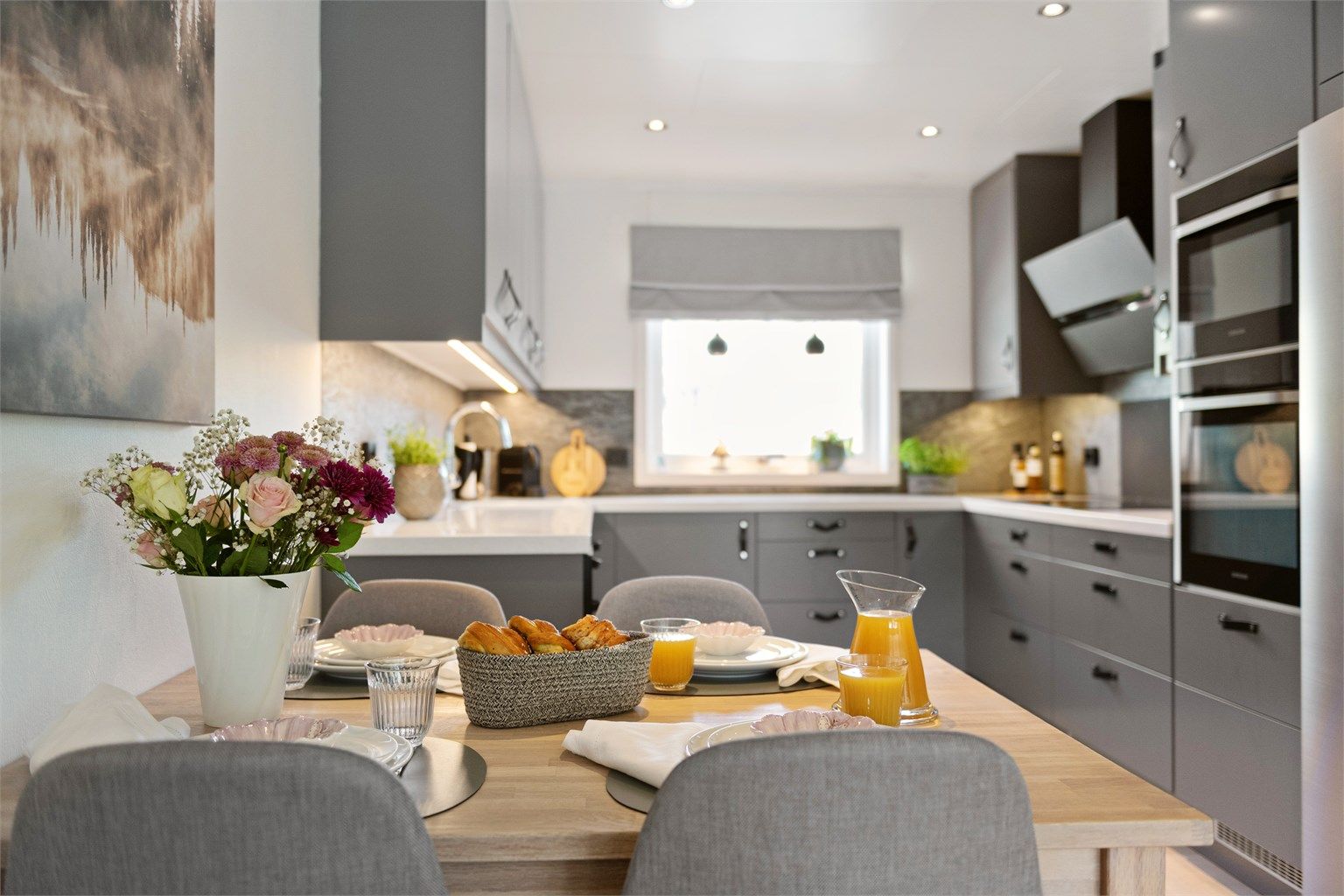 En hyggelig plass for frokost med utsikt mot nærområdet fra kjøkkenvinduet.