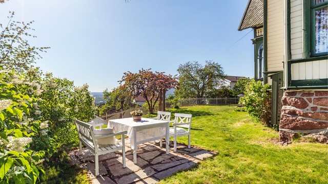 En hellelagt uteplass med plass til sittegruppe