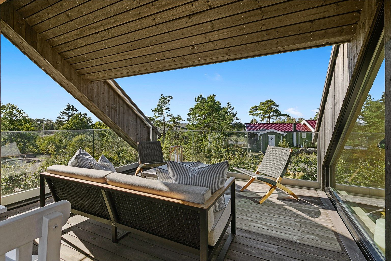  Delvis overbygget takterrasse på ca. 24 m² med moderne rekkverk i glass og metall.