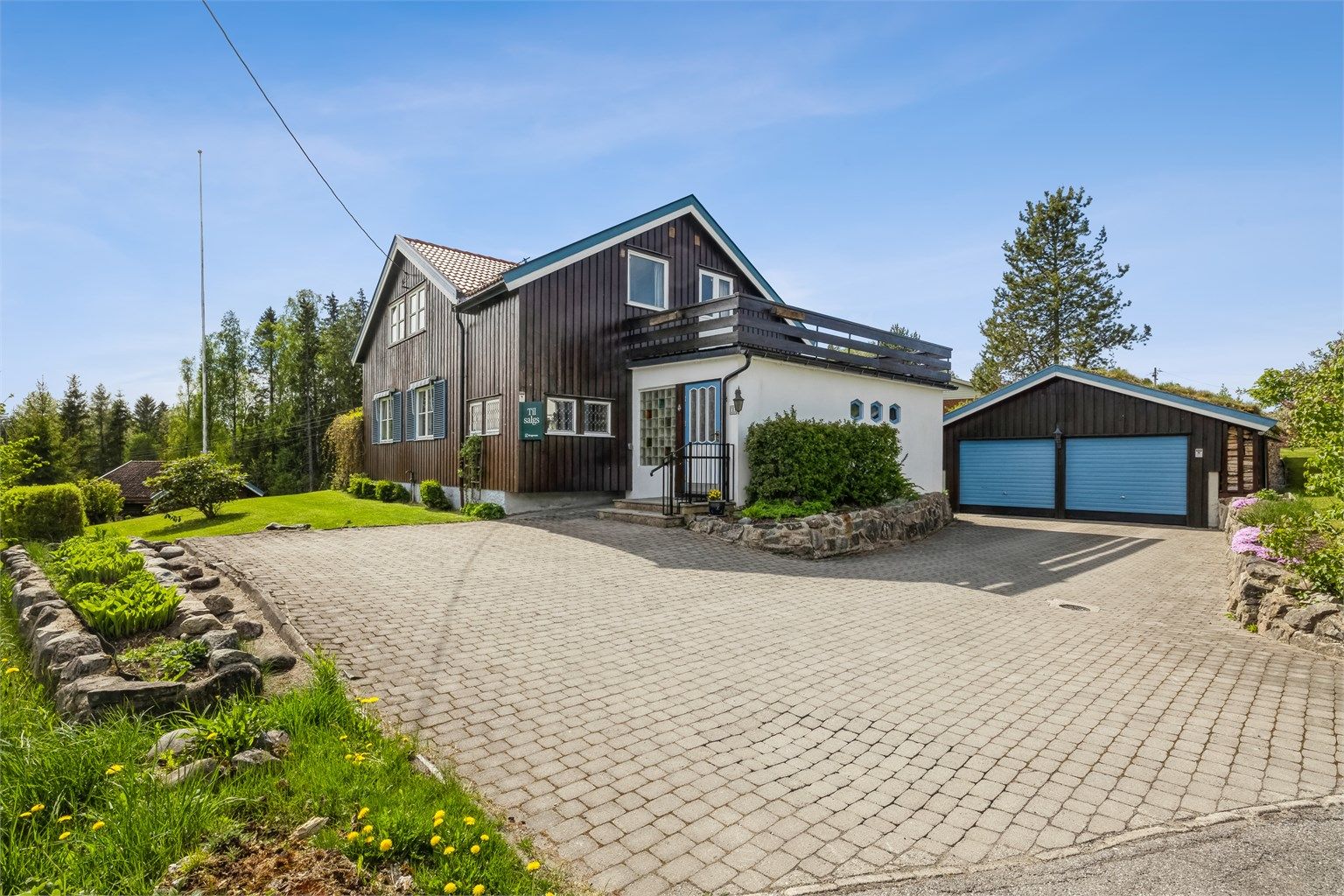 Pent opparbeidet tomt med steinbelagt gårdsplass og romslig hageareal