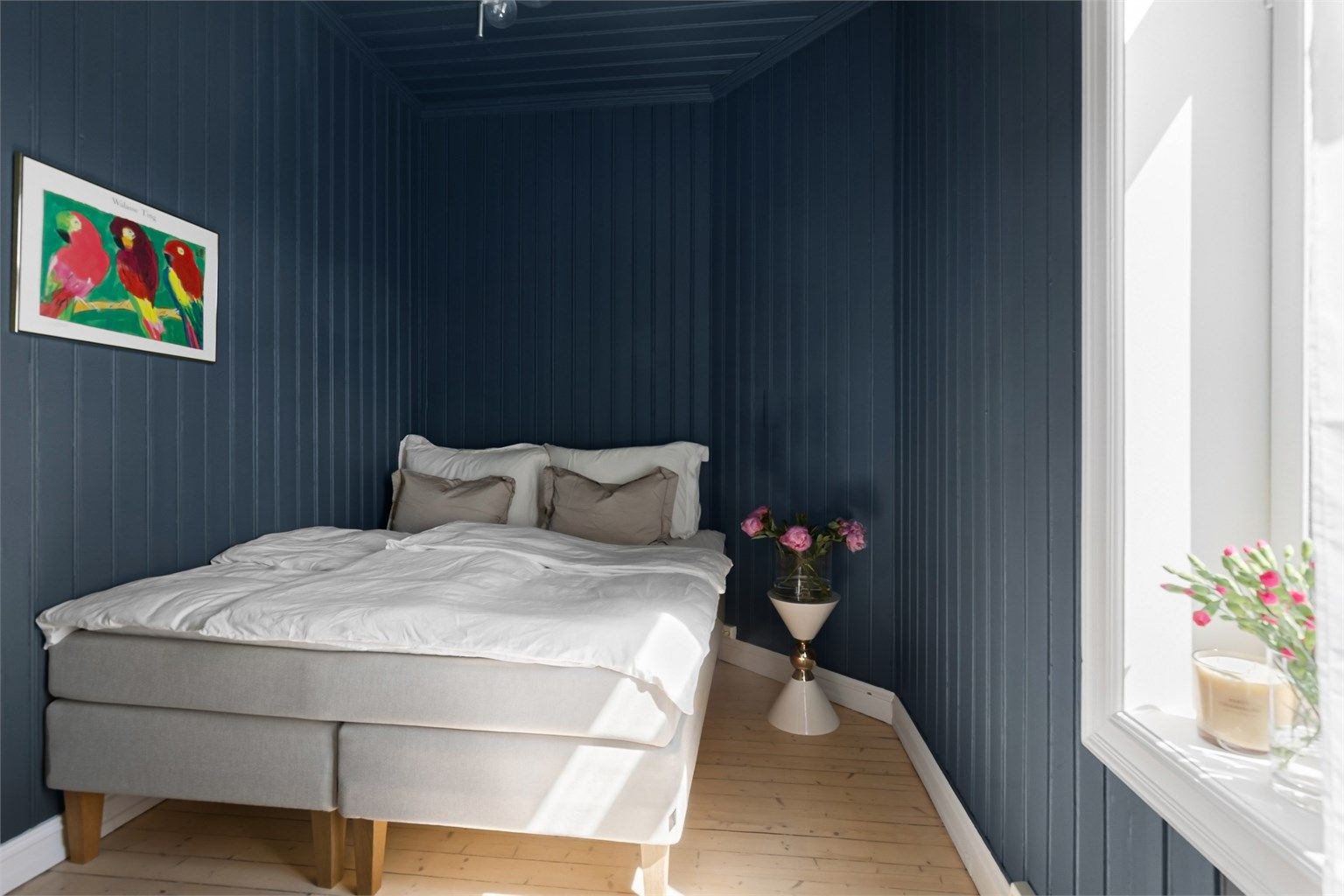 Det ene soverommet har malt trepanel i himling og på vegger, og vender mot den rolige bakgården.