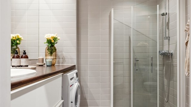 Innredningen består av fliser på gulv og vegger. Ellers er det gulvstående toalett, benkeplate med nedfelt servant og opplegg for vaskemaskin.