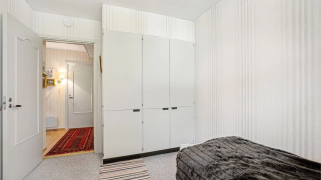 Lyst soverom med klesoppbevaring i garderobeskap.
