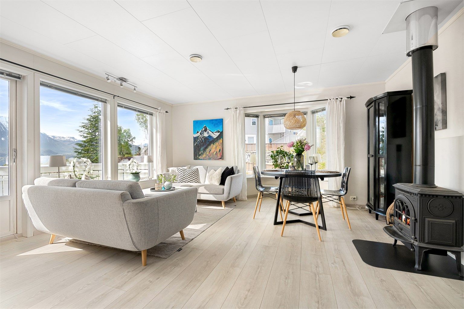 De store vinduene slipper inn rikelig med lys og rammer inn utsikten mot Hjørundfjorden.