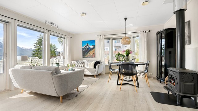 De store vinduene slipper inn rikelig med lys og rammer inn utsikten mot Hjørundfjorden.
