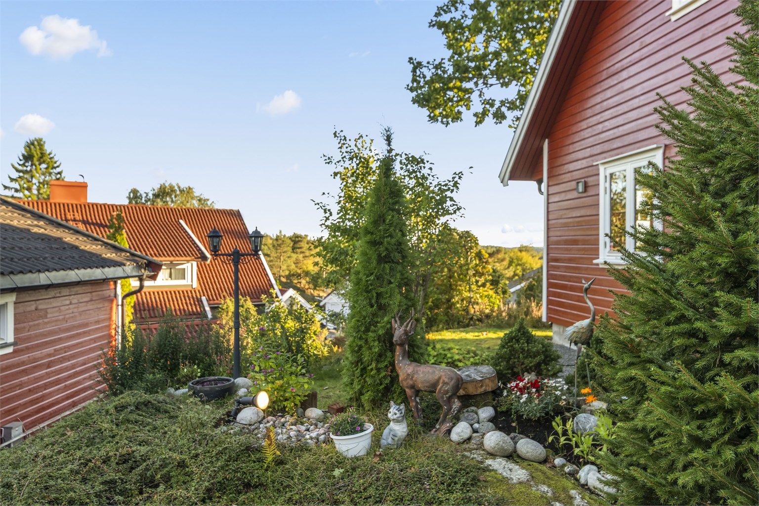 Pent opparbeidet beplantning og steinbed langs adkomsten til huset.