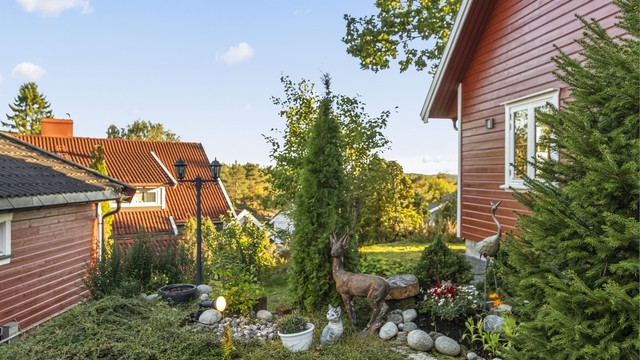 Pent opparbeidet beplantning og steinbed langs adkomsten til huset.