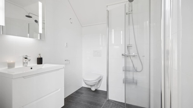 Badet i 3.etg har moderne lekre fliser, gulvvarme, vegghengt toalett og servantskap med god plass samt dusjhjørnet med praktiske innfellbare dører.