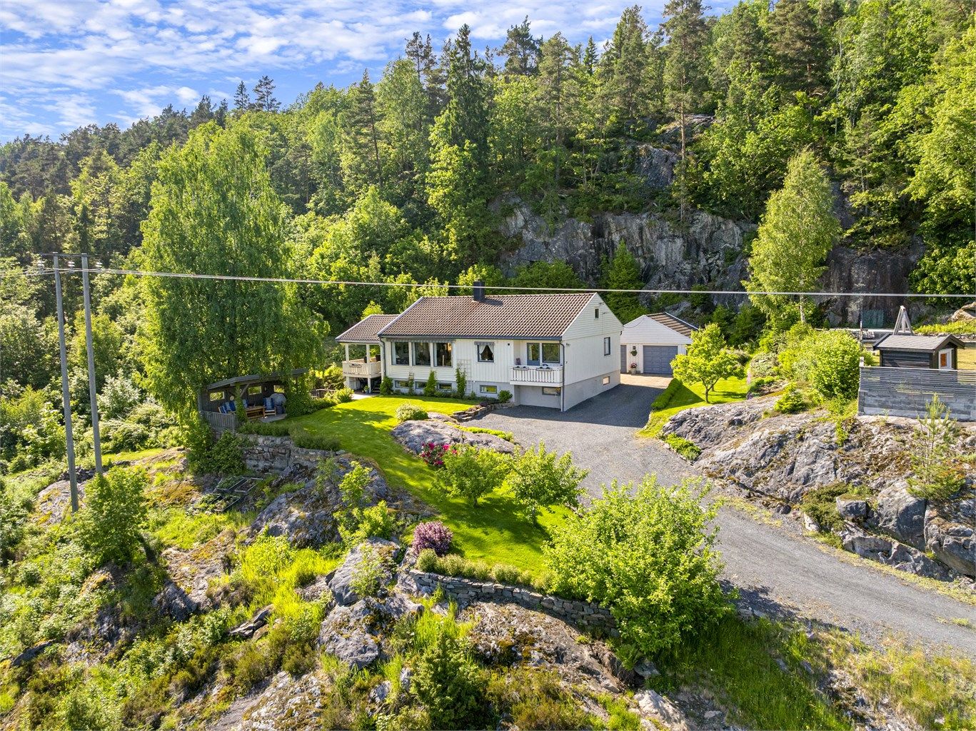 Oversikt over den store tomten med bolighus og frittstående garasje.