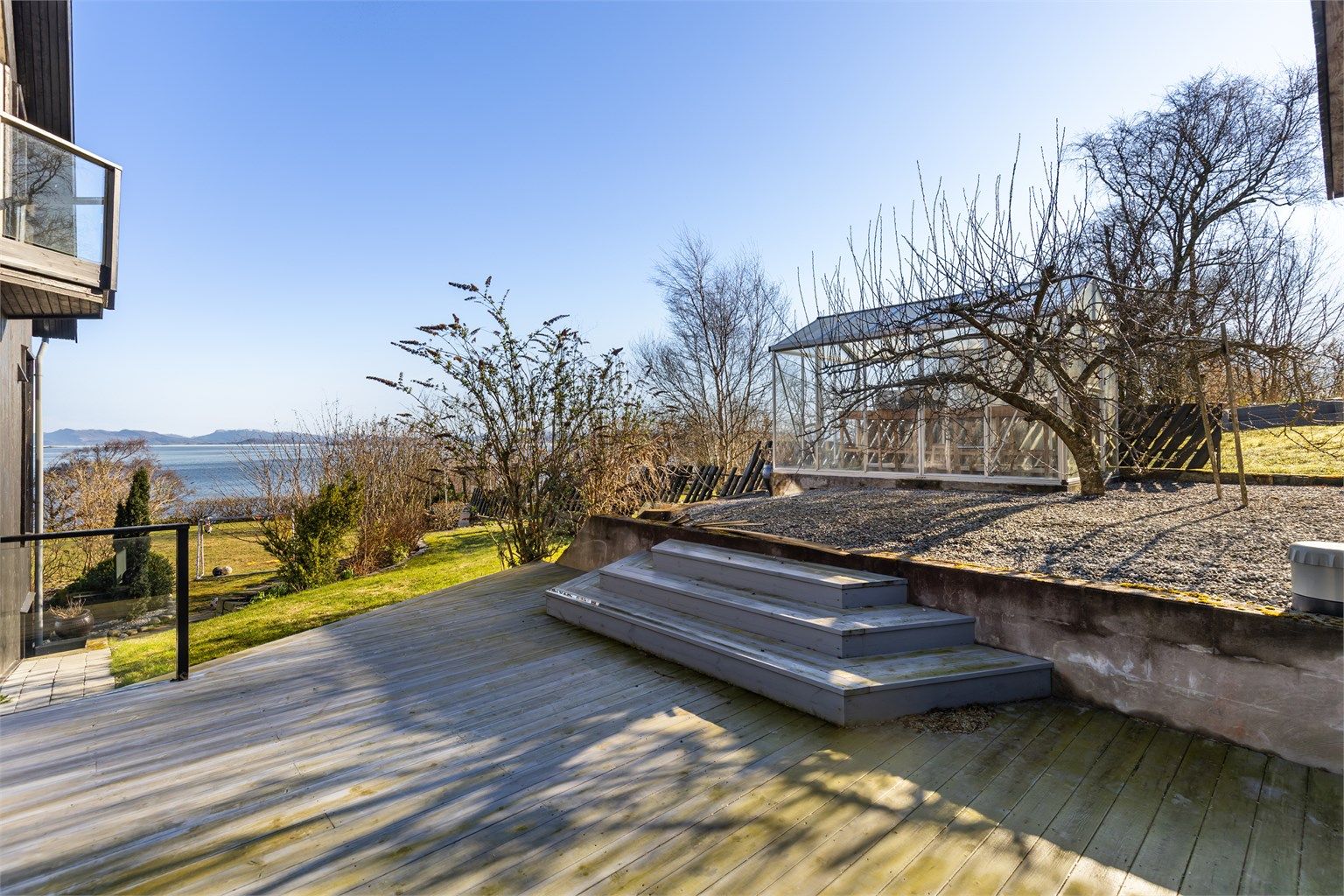 Tomten er opparbeidet med plenarealer, diverse beplantning og store terrasseflater.