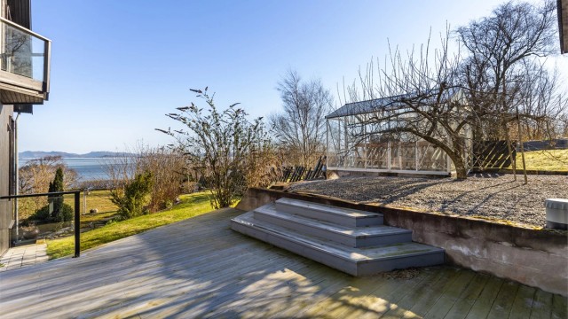 Tomten er opparbeidet med plenarealer, diverse beplantning og store terrasseflater.