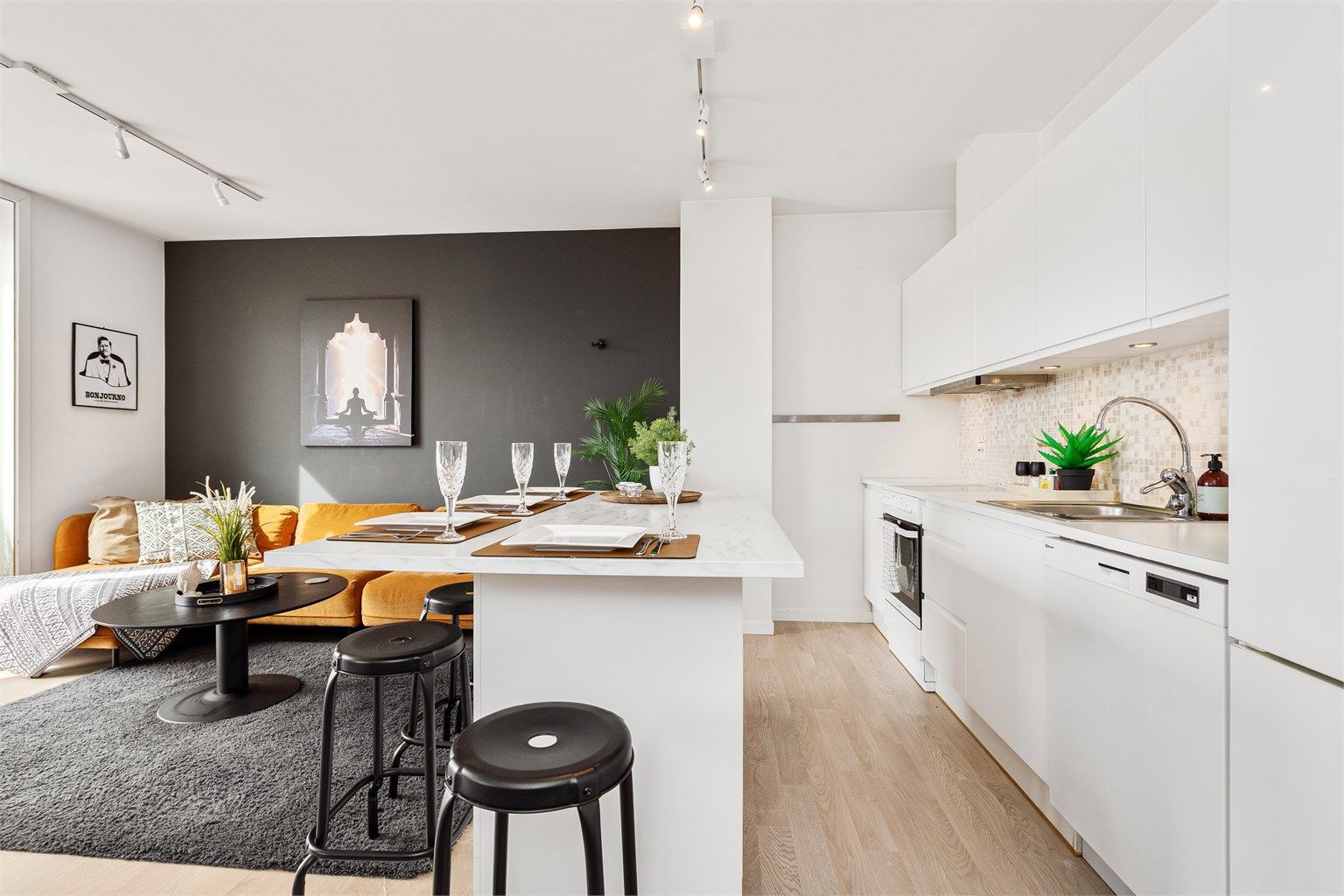 Åpen stue og kjøkkenløsning med praktisk kjøkkenøy med sitteplasser - en arealeffektiv løsning i rommet 