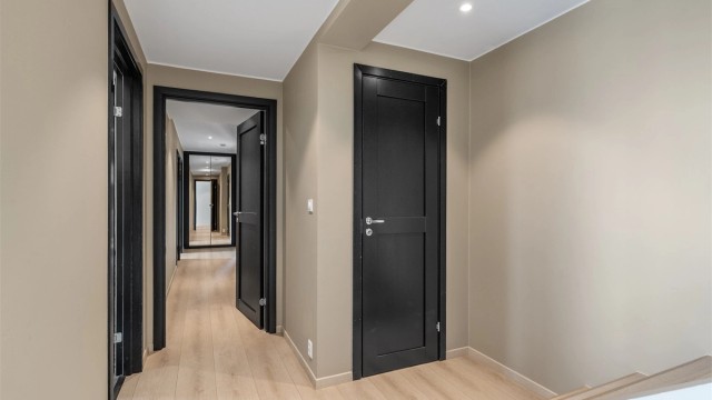 Gangen i første etasje har laminatgulv og downlights i himlingen. ( dør rett fremfor trappen er en bod )