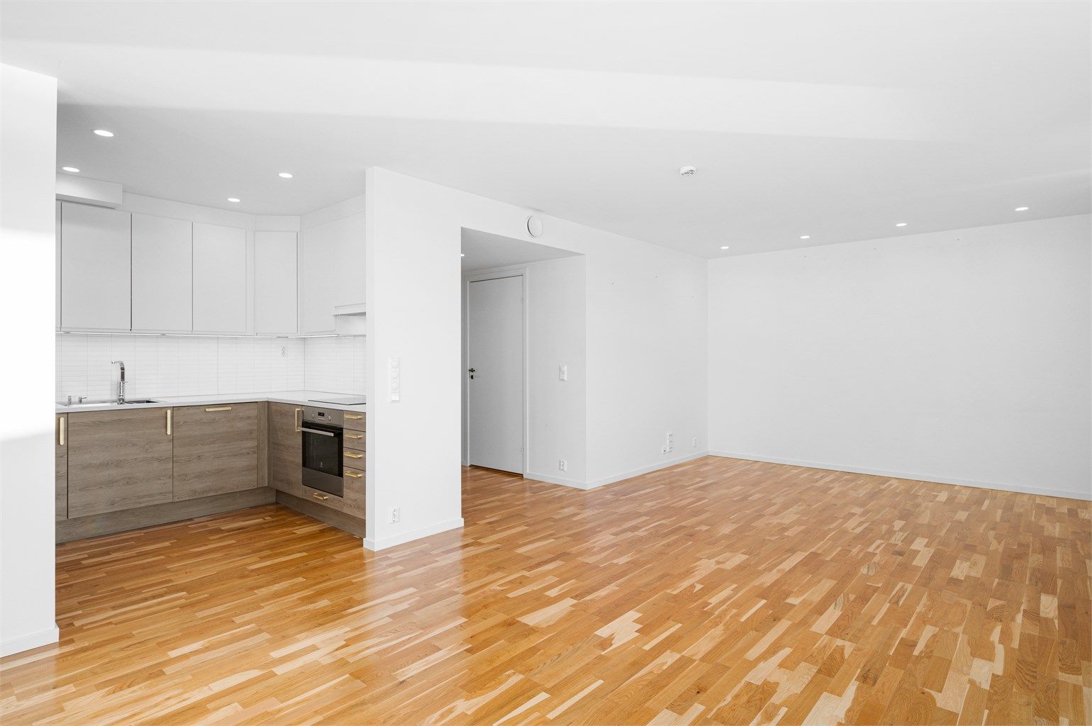 Kjøkkenet ligger naturlig tilbaketrukket fra stuen og har rikelig med skap- og benkeplass å boltre seg på. 