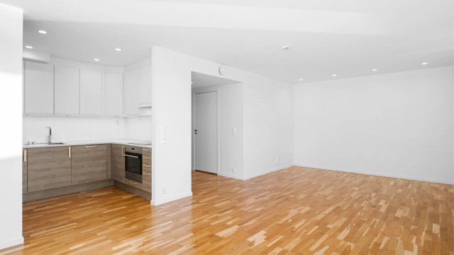 Kjøkkenet ligger naturlig tilbaketrukket fra stuen og har rikelig med skap- og benkeplass å boltre seg på.