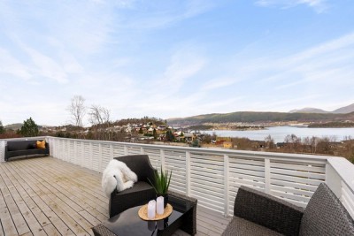 Stor veranda i husets lengde mot nordvest med flott utsikt mot fjord og fjell